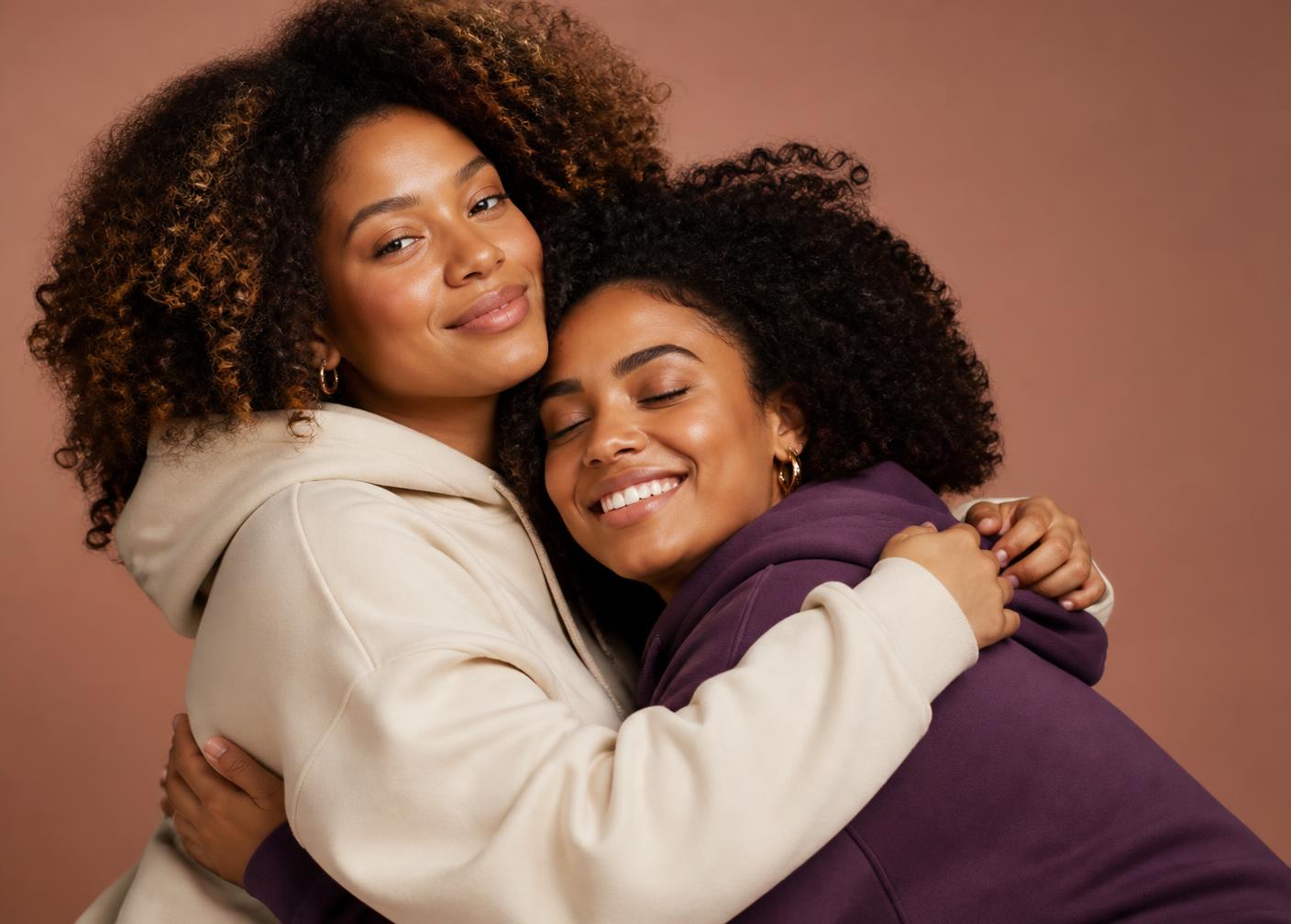 Duas mulheres se abraçando vestindo moletons do movimento